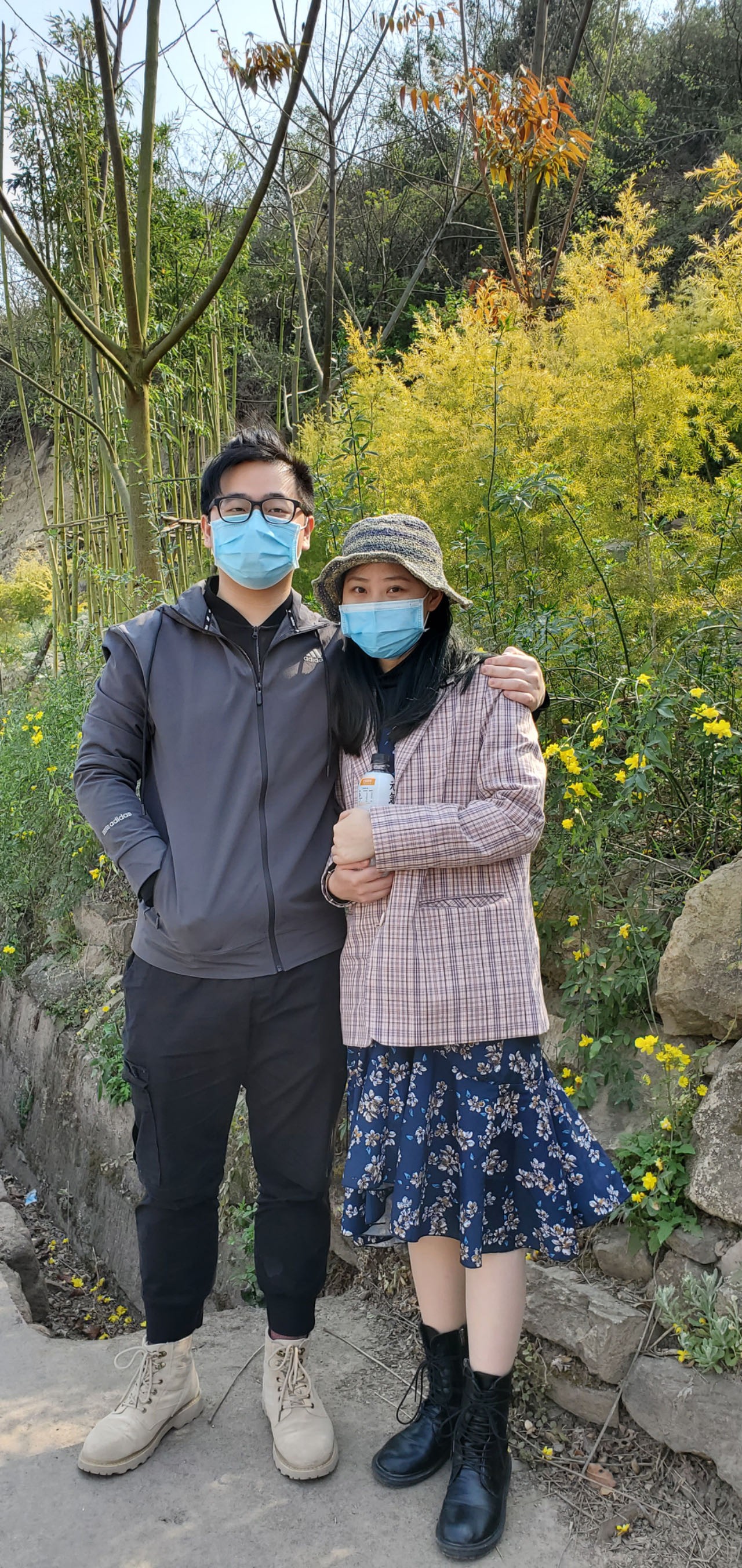 情侣旅行照片，站在海边夕阳下，两人手牵手背影，天空呈现橙红色晚霞